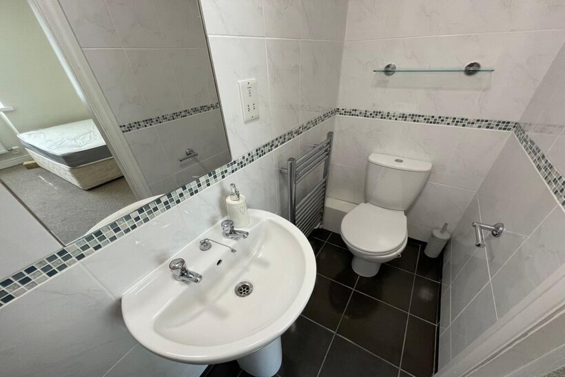 A clean and tidy small bathroom featuring white...