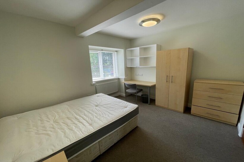 A cozy bedroom featuring a single bed, large wi...