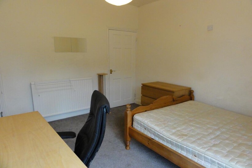 A cozy student single bedroom featuring a woode...