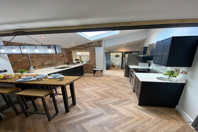 Modern kitchen featuring sleek black cabinets, ...