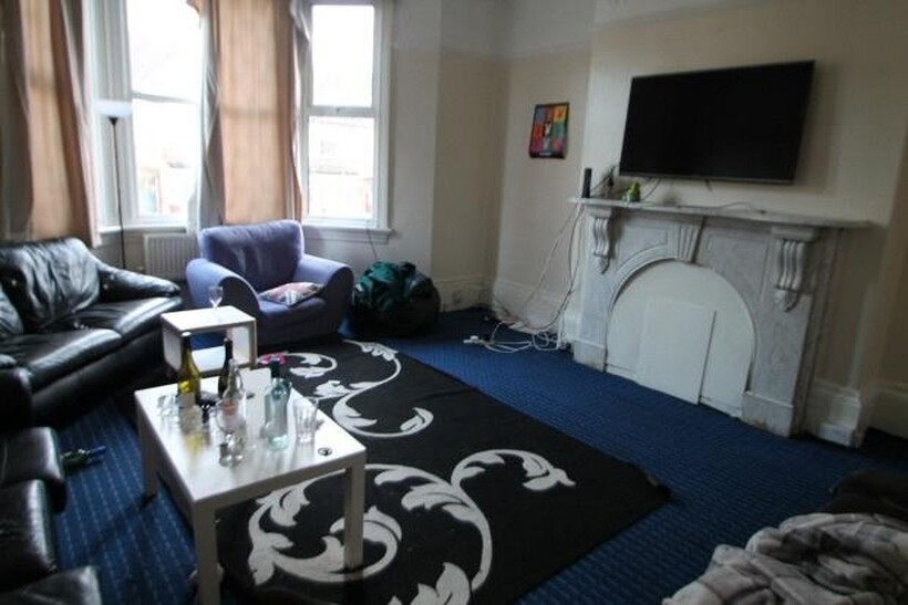 A spacious and bright living room featuring com...