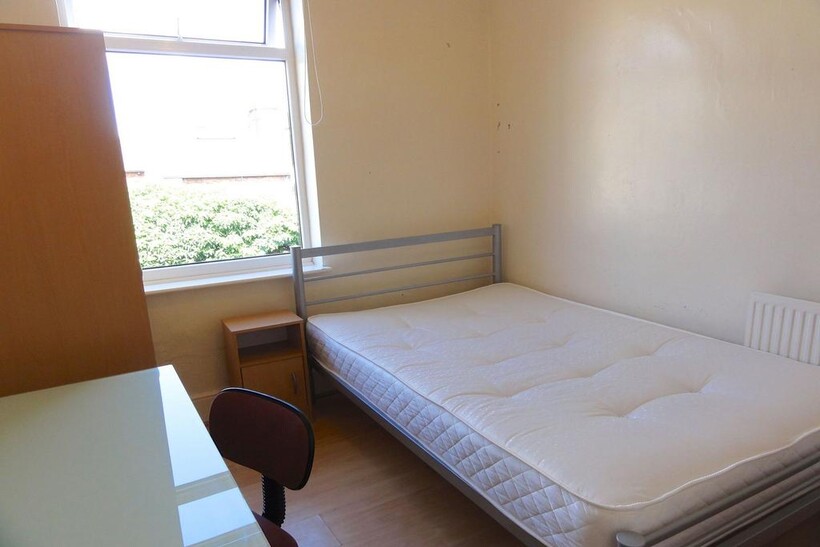 A cozy bedroom featuring a single bed positione...