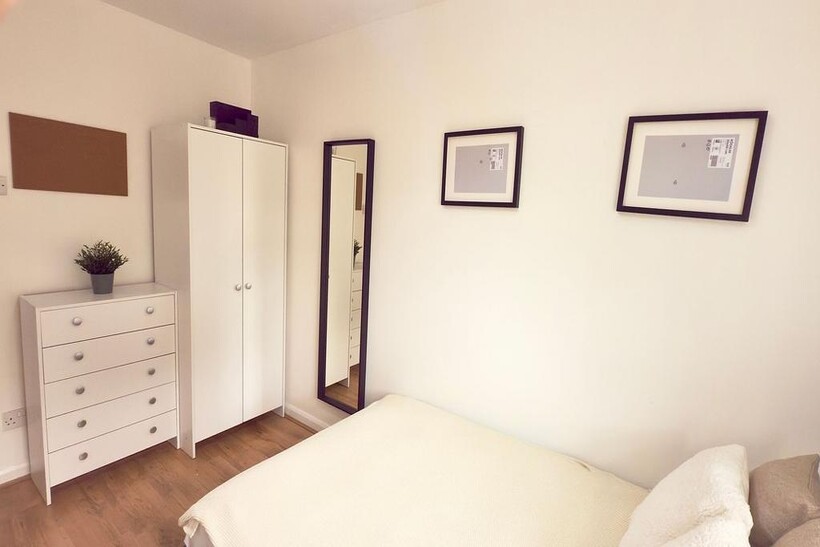 Bright and tidy bedroom featuring a comfortable...