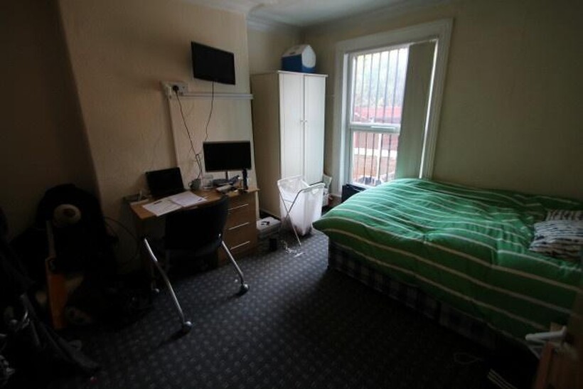 A cozy bedroom featuring a double bed with a gr...