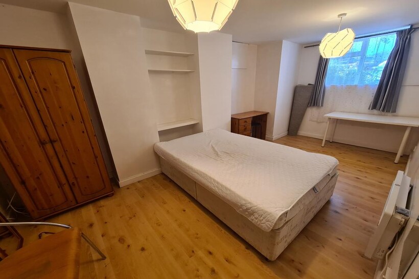 A bright and tidy bedroom featuring a comfortab...