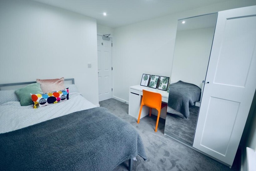 A tidy and well-lit bedroom featuring a comfort...