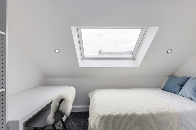 Bright and airy master bedroom featuring a larg...