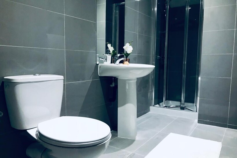 Modern, clean bathroom suite featuring a large ...