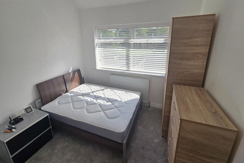 A well-lit, neatly maintained double bedroom wi...