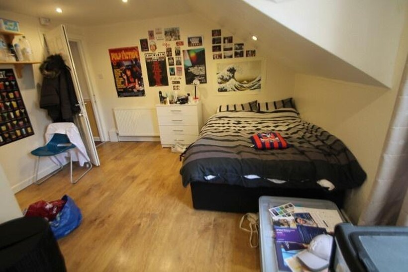 A well-lit spacious bedroom with a double bed, ...