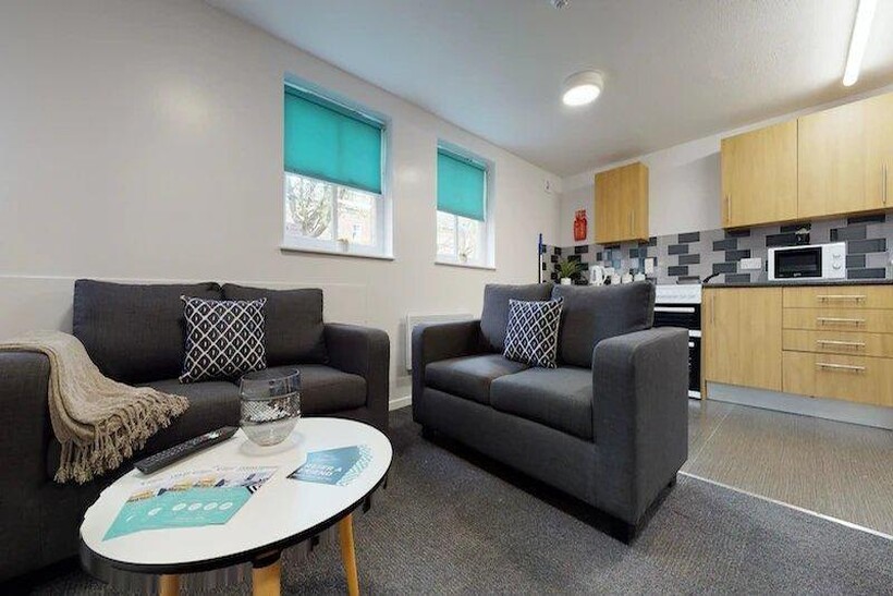 A spacious, well-lit living room featuring two ...