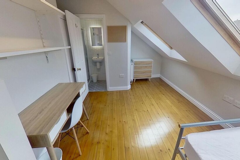 Bright and clean bedroom featuring wooden floor...