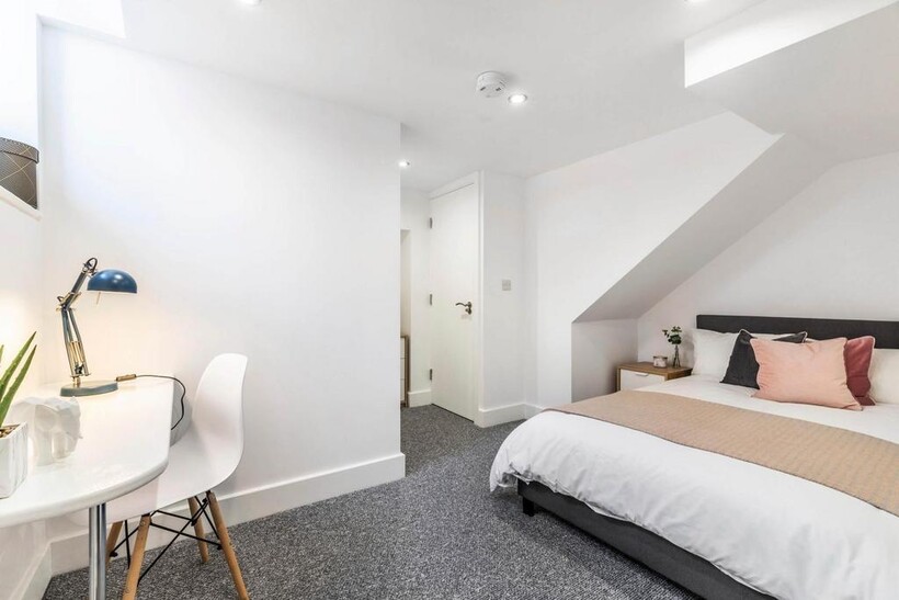 A bright and modern bedroom featuring a comfort...