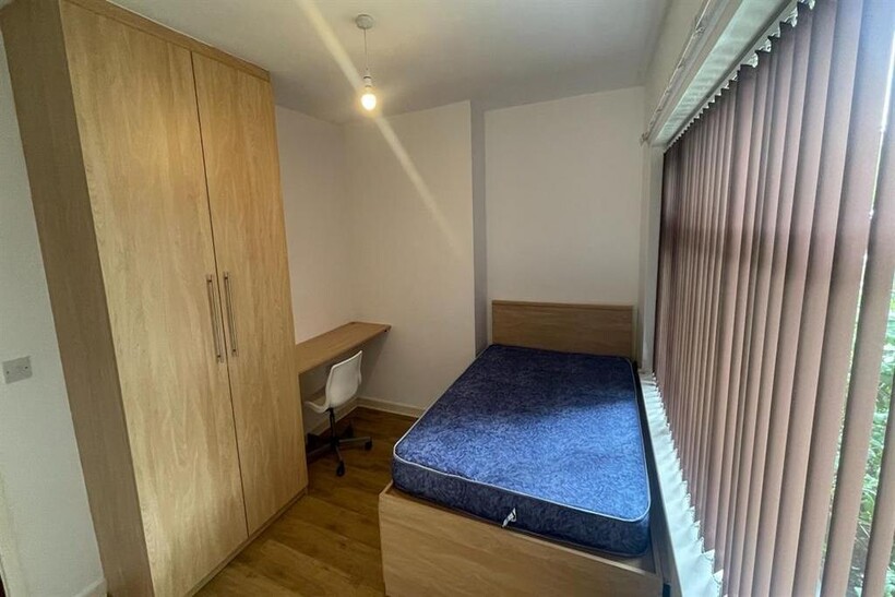 A bright and tidy single bedroom featuring a co...