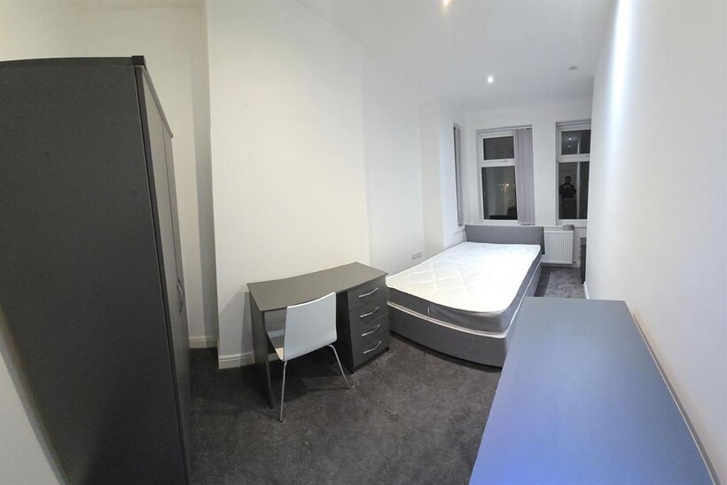 A bright and tidy bedroom featuring a comfortab...