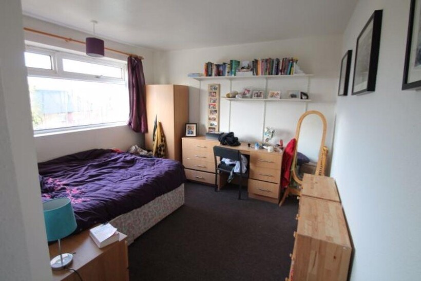 A cozy and well-lit bedroom featuring a comfort...