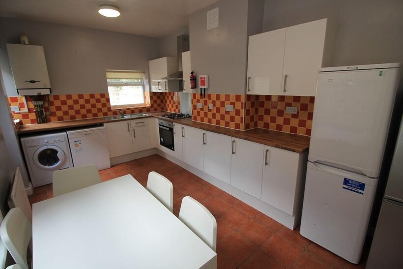 Bright and clean kitchen with ample white cabin...