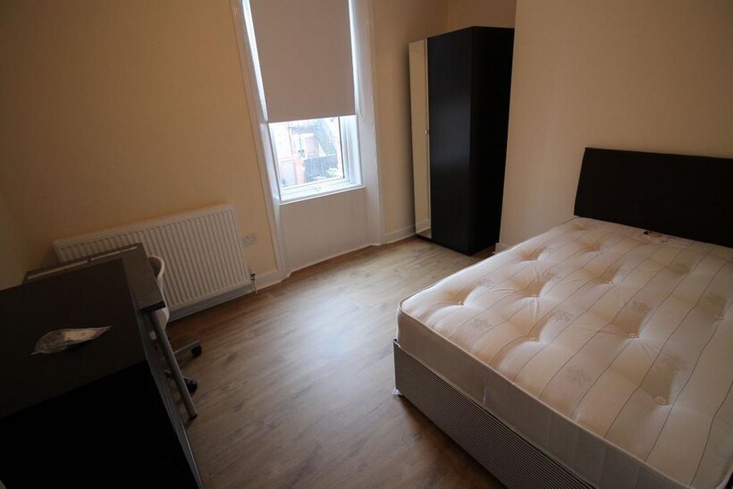 A well-maintained bedroom featuring a double be...