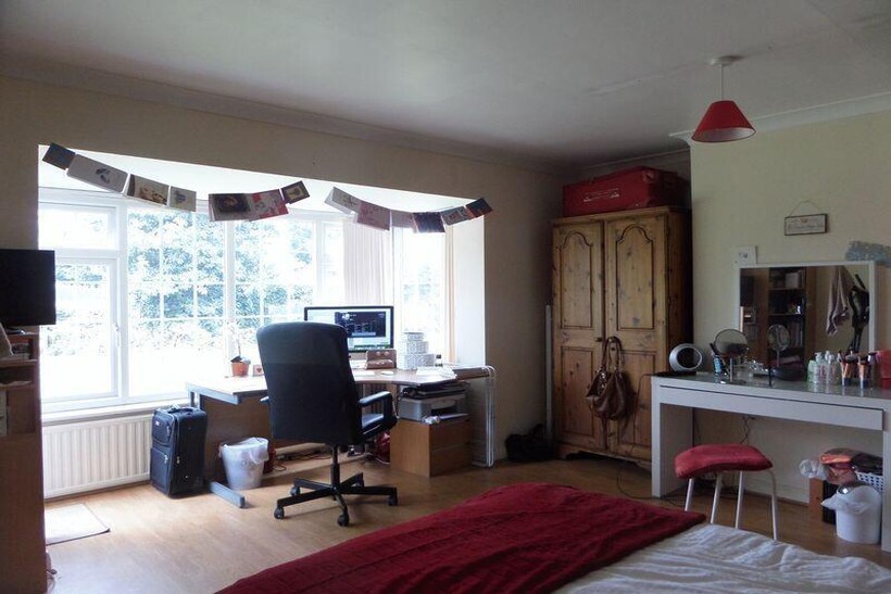 A spacious and well-lit living room featuring a...