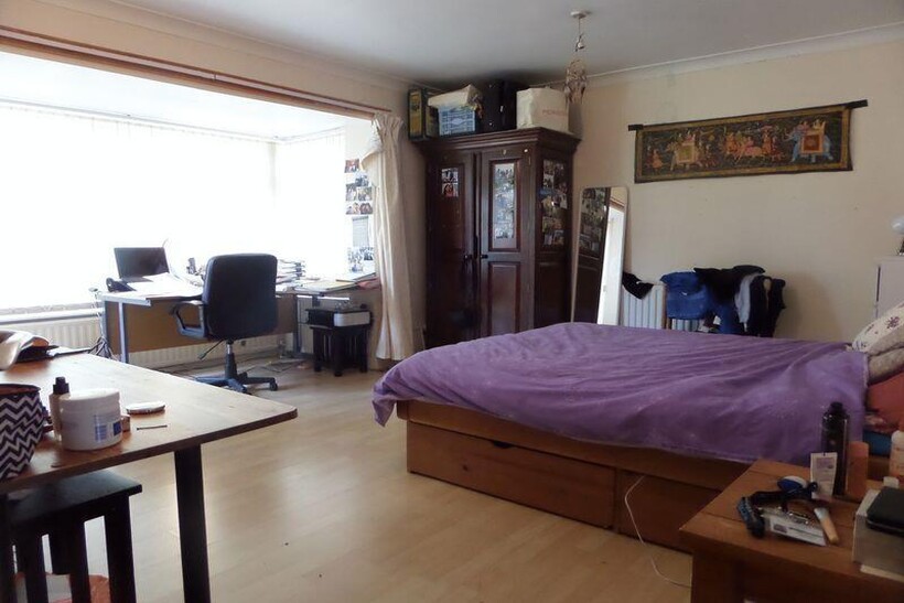 A spacious and well-lit master bedroom featurin...