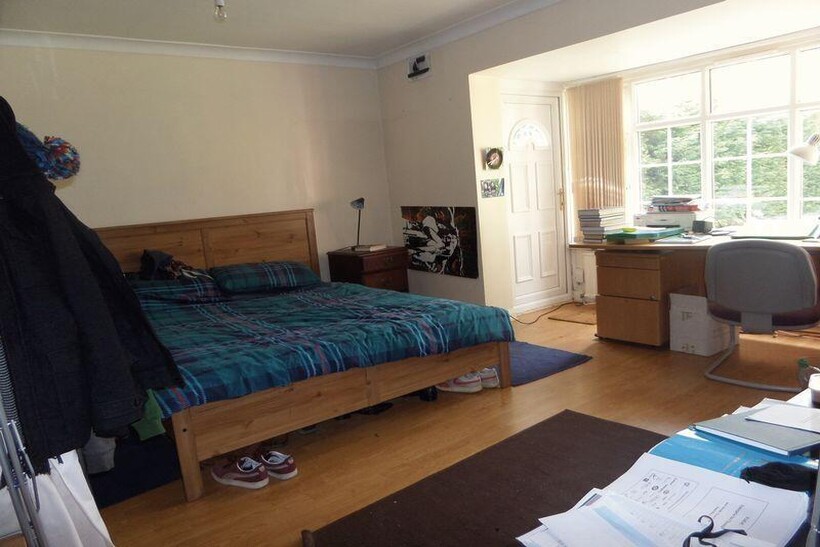 A well-lit bedroom featuring a spacious layout ...