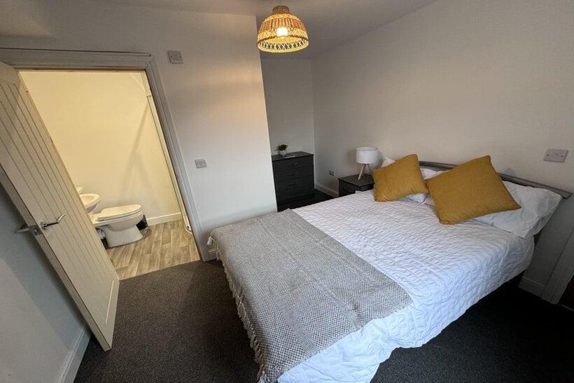 Bright and cozy master bedroom featuring a comf...