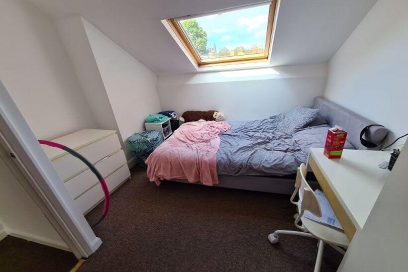 A bright and cozy master bedroom with a large w...