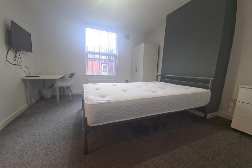 A bright, spacious master bedroom featuring a c...