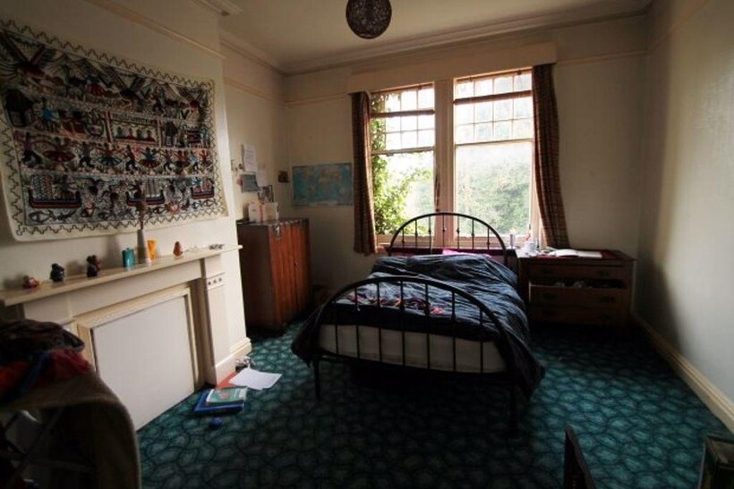 A spacious master bedroom featuring a large win...