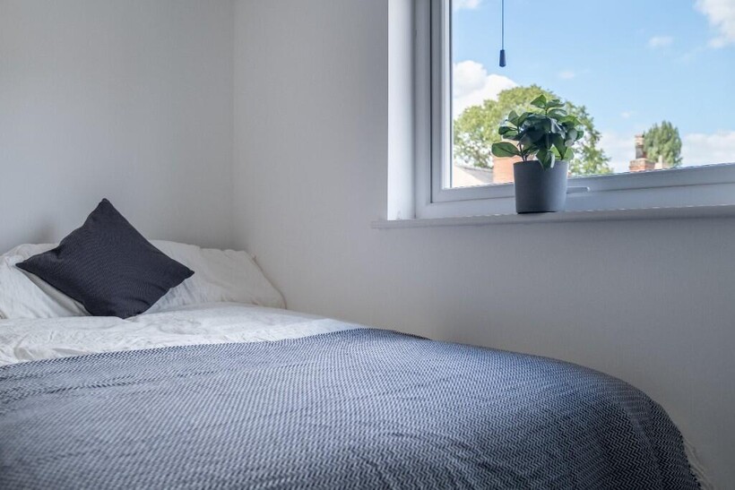 A bright and tidy bedroom featuring a comfortab...