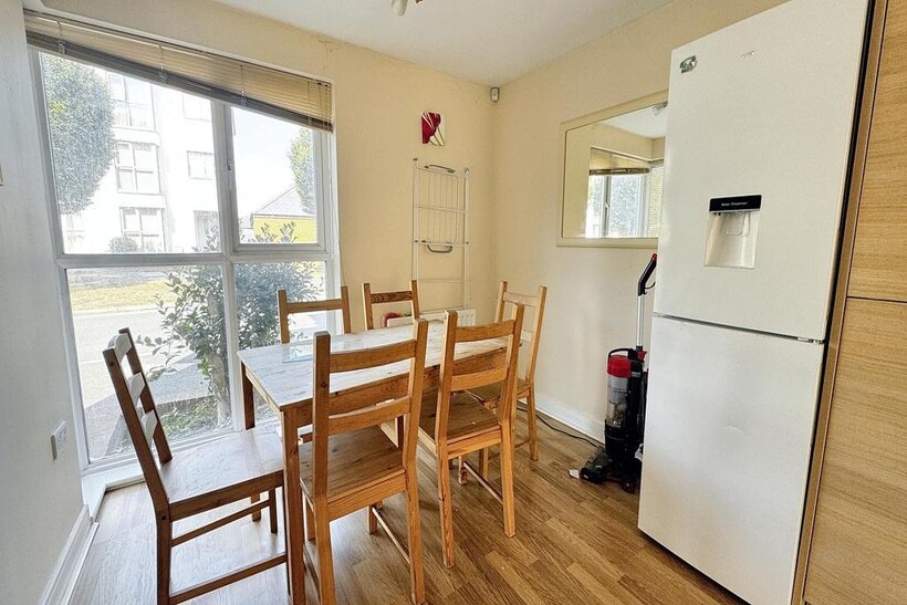A bright, tidy living room featuring large wind...