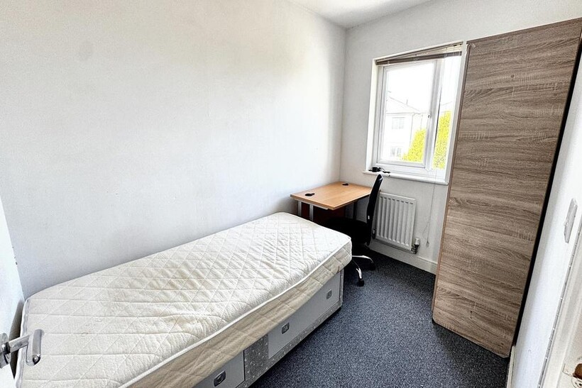 A compact single bedroom with a single bed, a w...