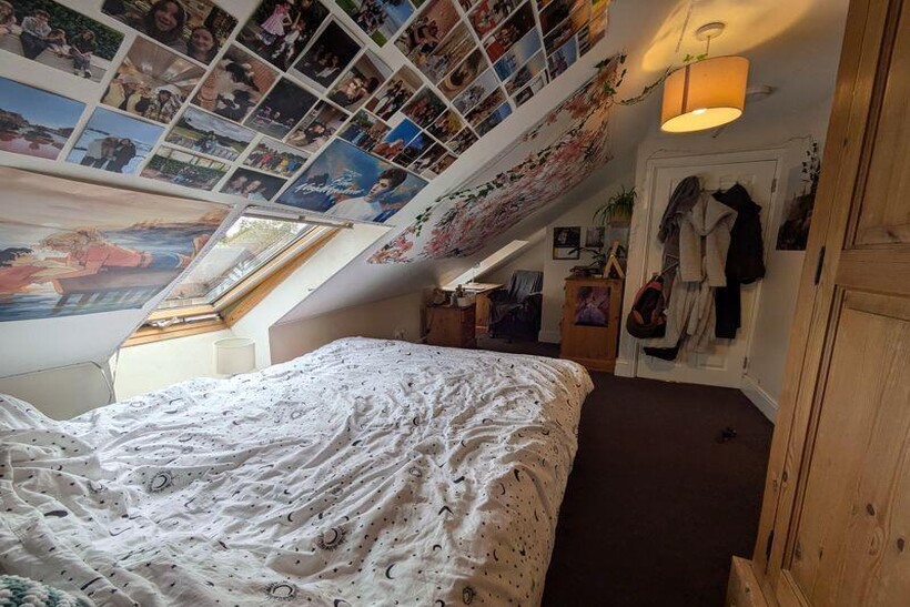 A cozy bedroom with a sloped ceiling and a larg...