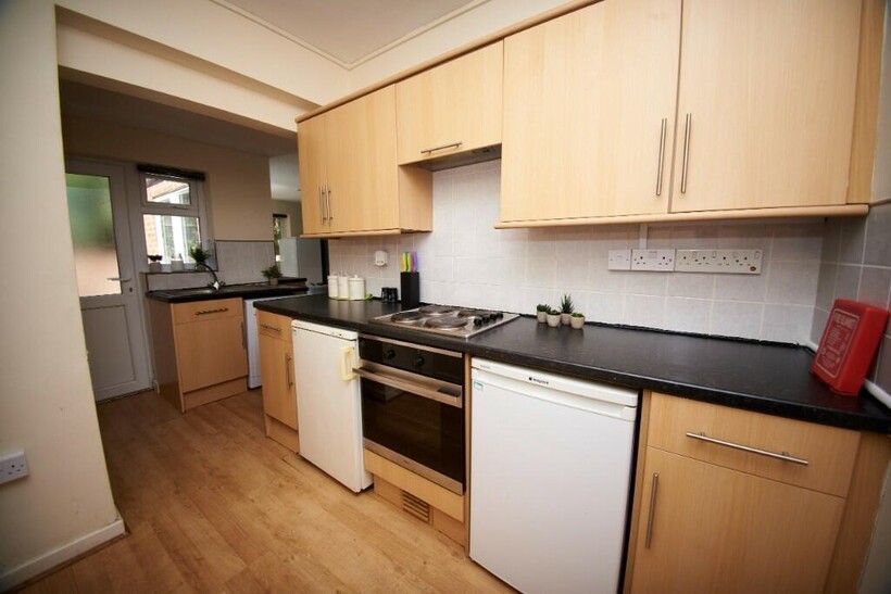 A modern, well-lit kitchen with wooden cabinetr...