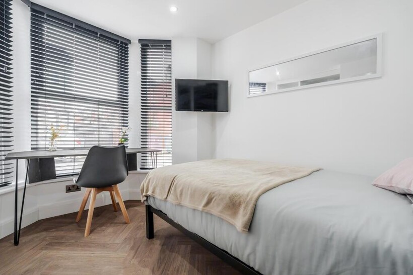 A modern, well-lit master bedroom featuring a c...