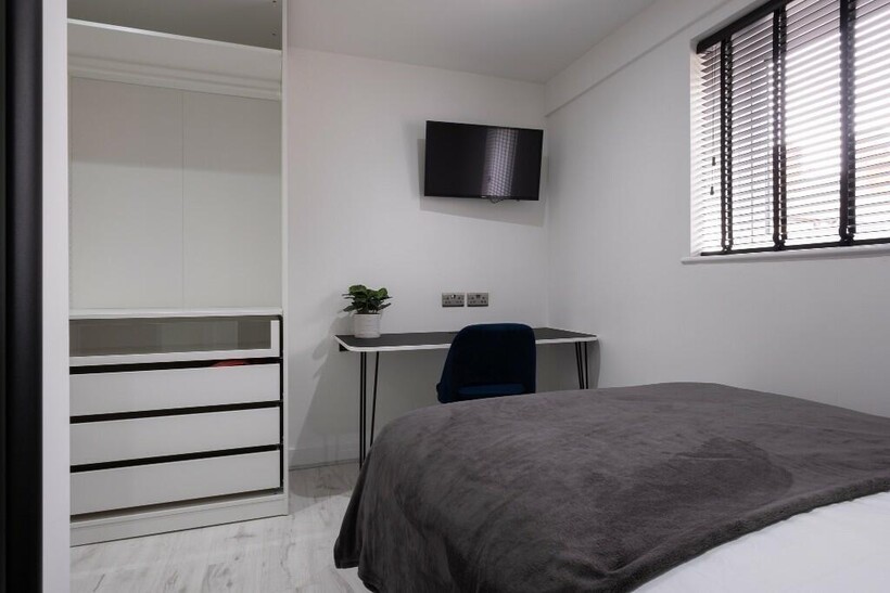 A modern, clean bedroom featuring a comfortable...