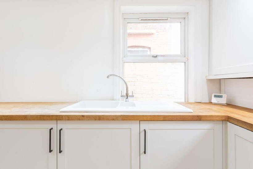Modern and bright kitchen with a white sink, wo...