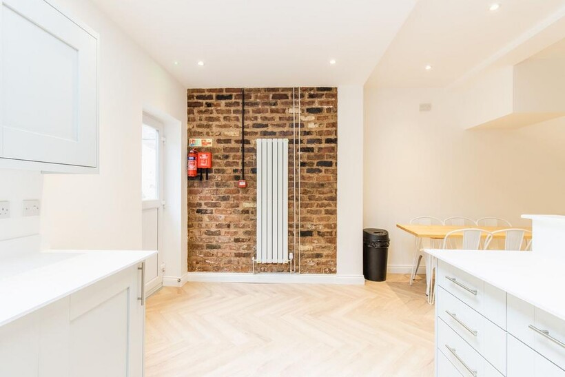 Bright, modern kitchen/dining area with white c...