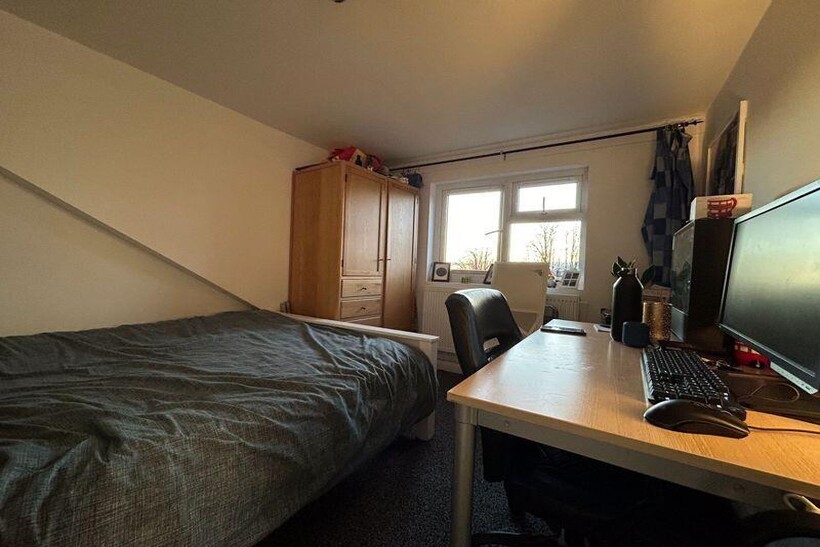 A cozy student bedroom featuring a single bed, ...