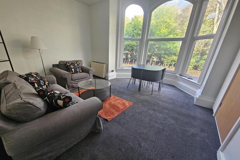 A bright and spacious living room featuring lar...