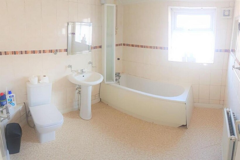 A clean and bright bathroom featuring a large b...