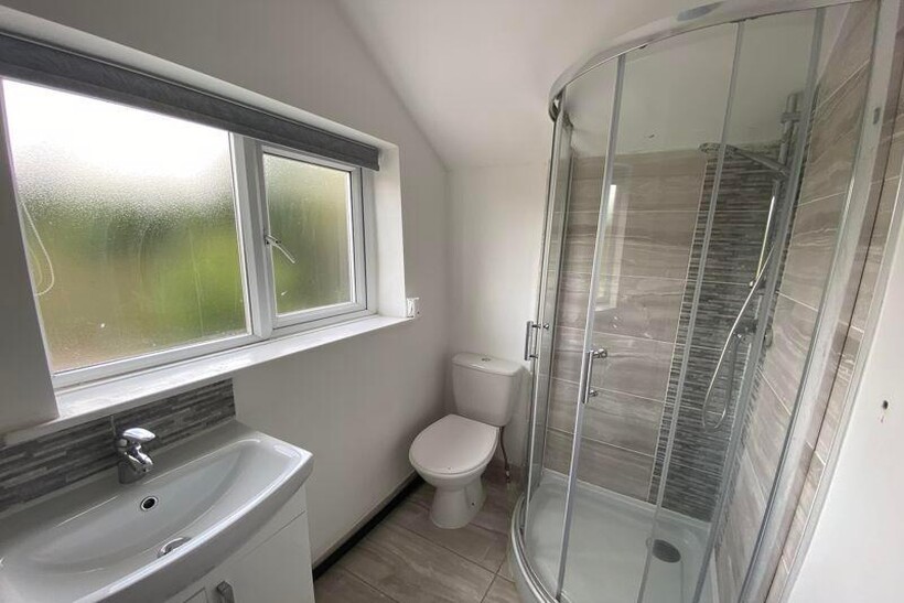 A clean and bright bathroom featuring a shower ...