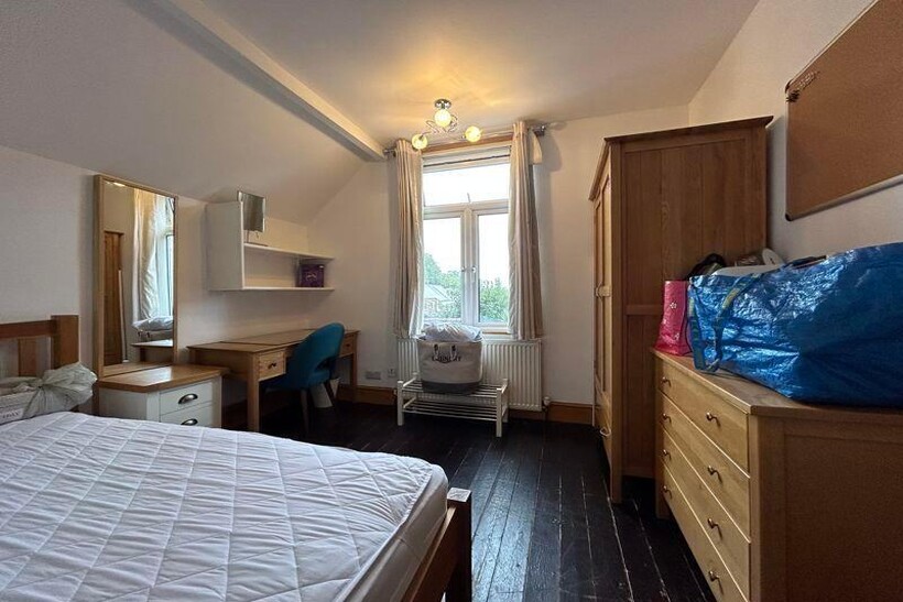 A cozy bedroom featuring a large window that of...