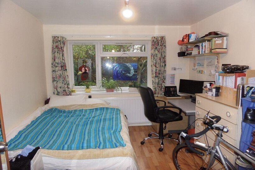 A cozy bedroom featuring a single bed with a co...