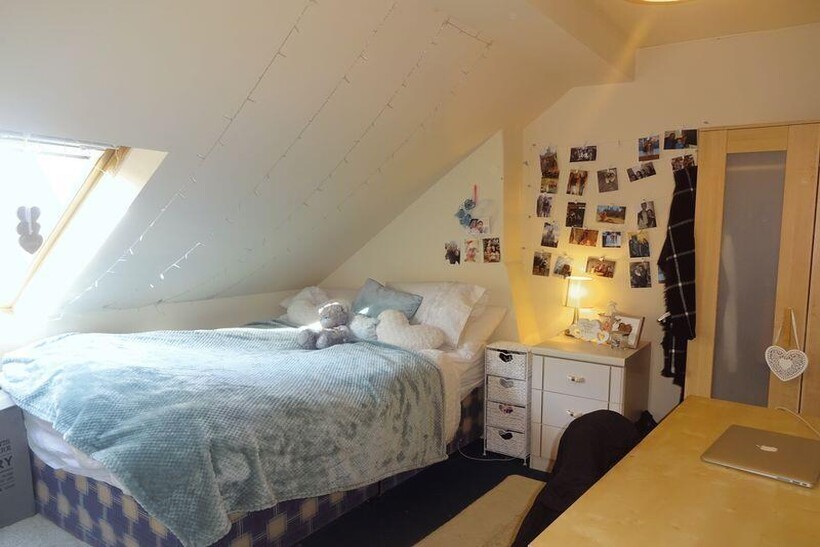 A cozy and well-lit bedroom featuring a double ...