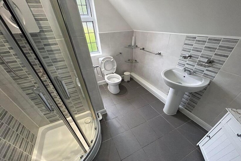 A bright and clean bathroom featuring a shower ...