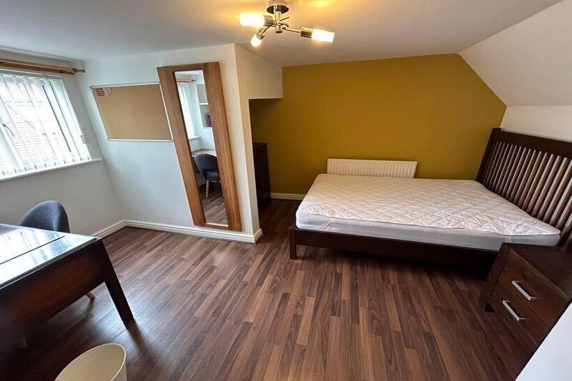 A tidy and well-lit bedroom featuring a double ...