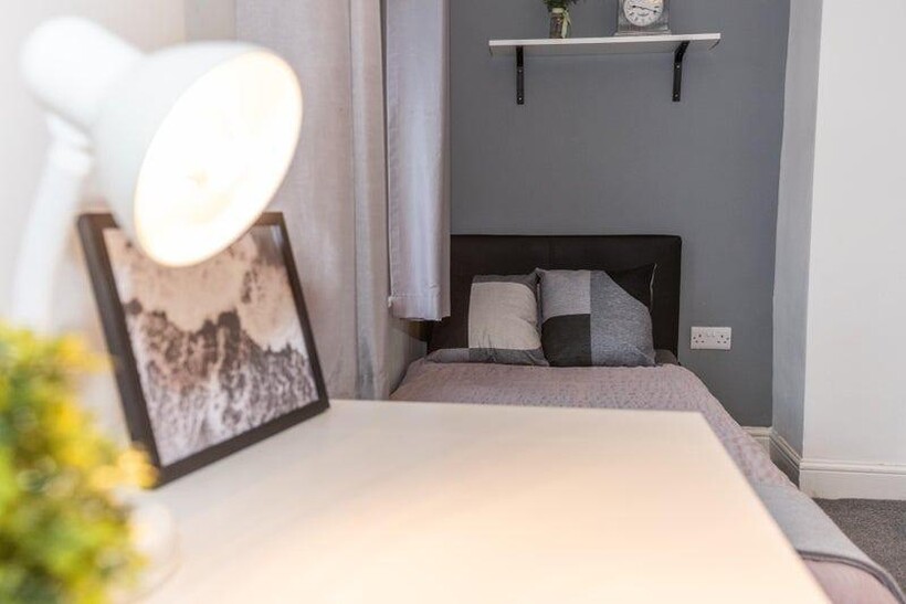 Bright, neatly styled bedroom with a single bed...