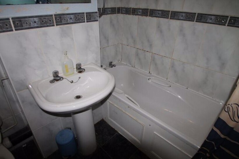 A well-maintained bathroom featuring a bathtub ...