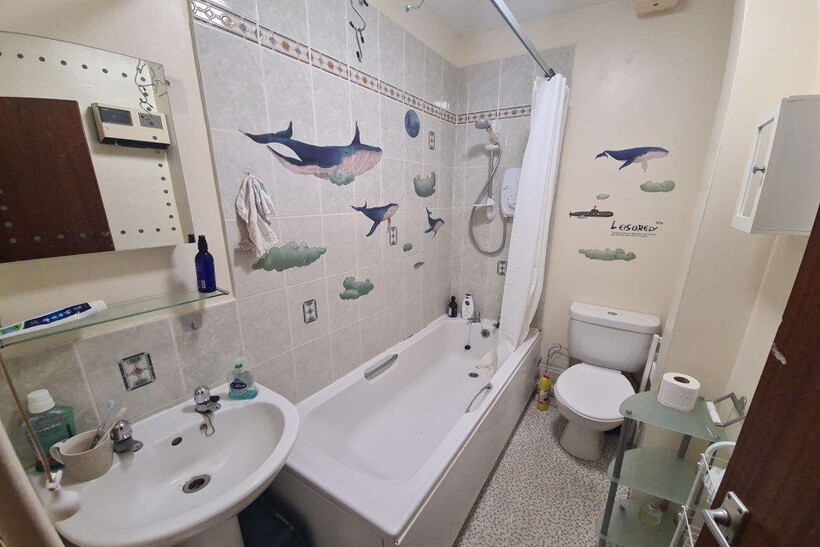 Bright, well-kept bathroom with a bathtub and s...
